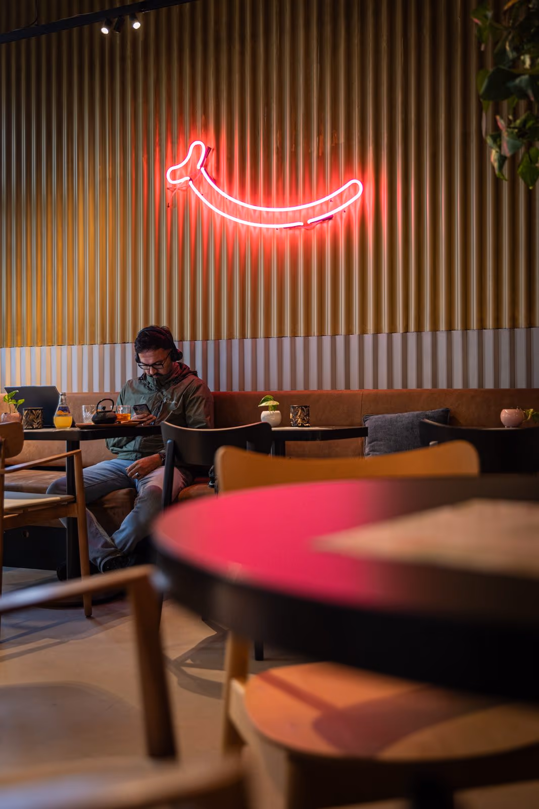 Roter Neon-Smiley über den Tischen