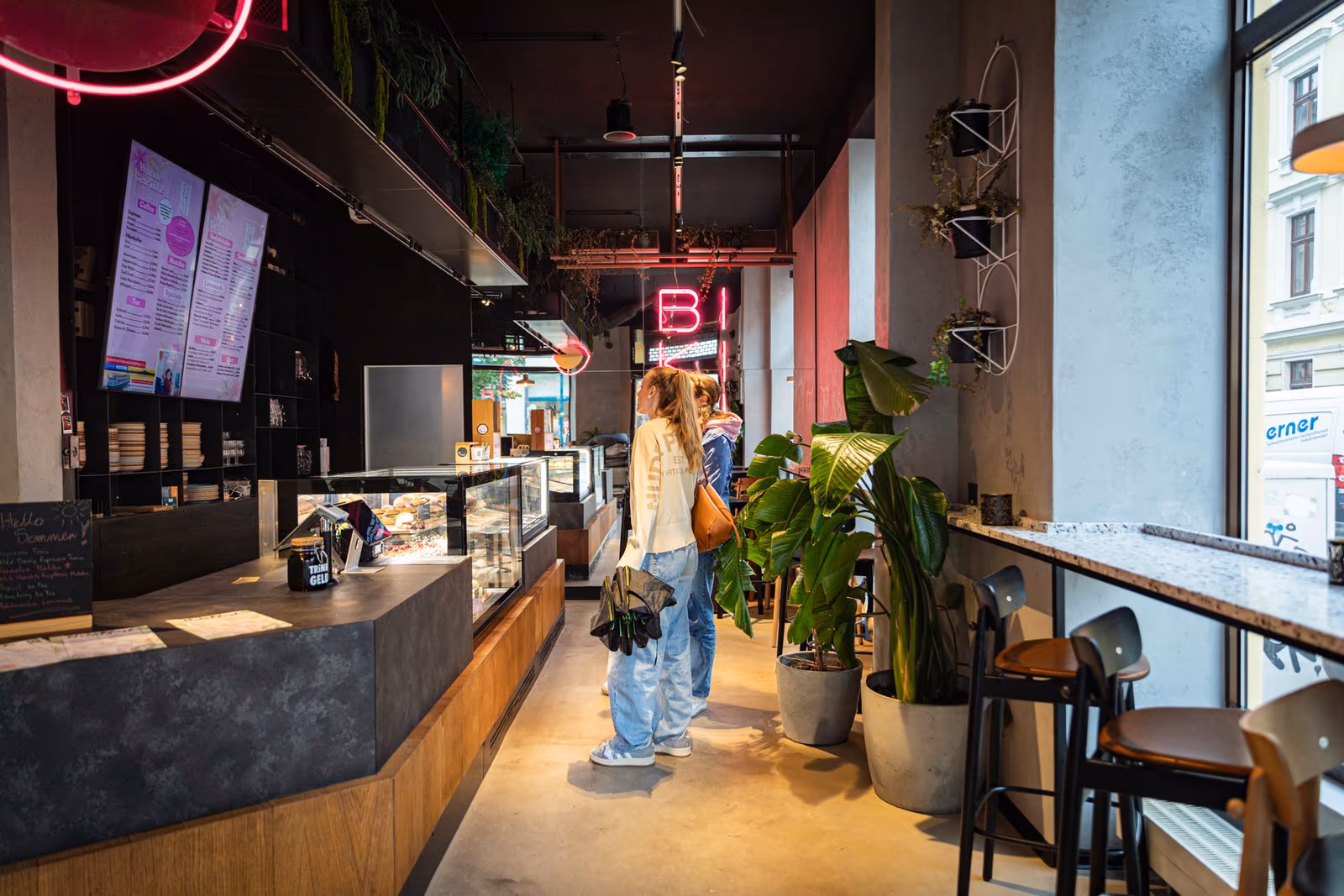 Gäste an der Theke mit Kuchenvitrine